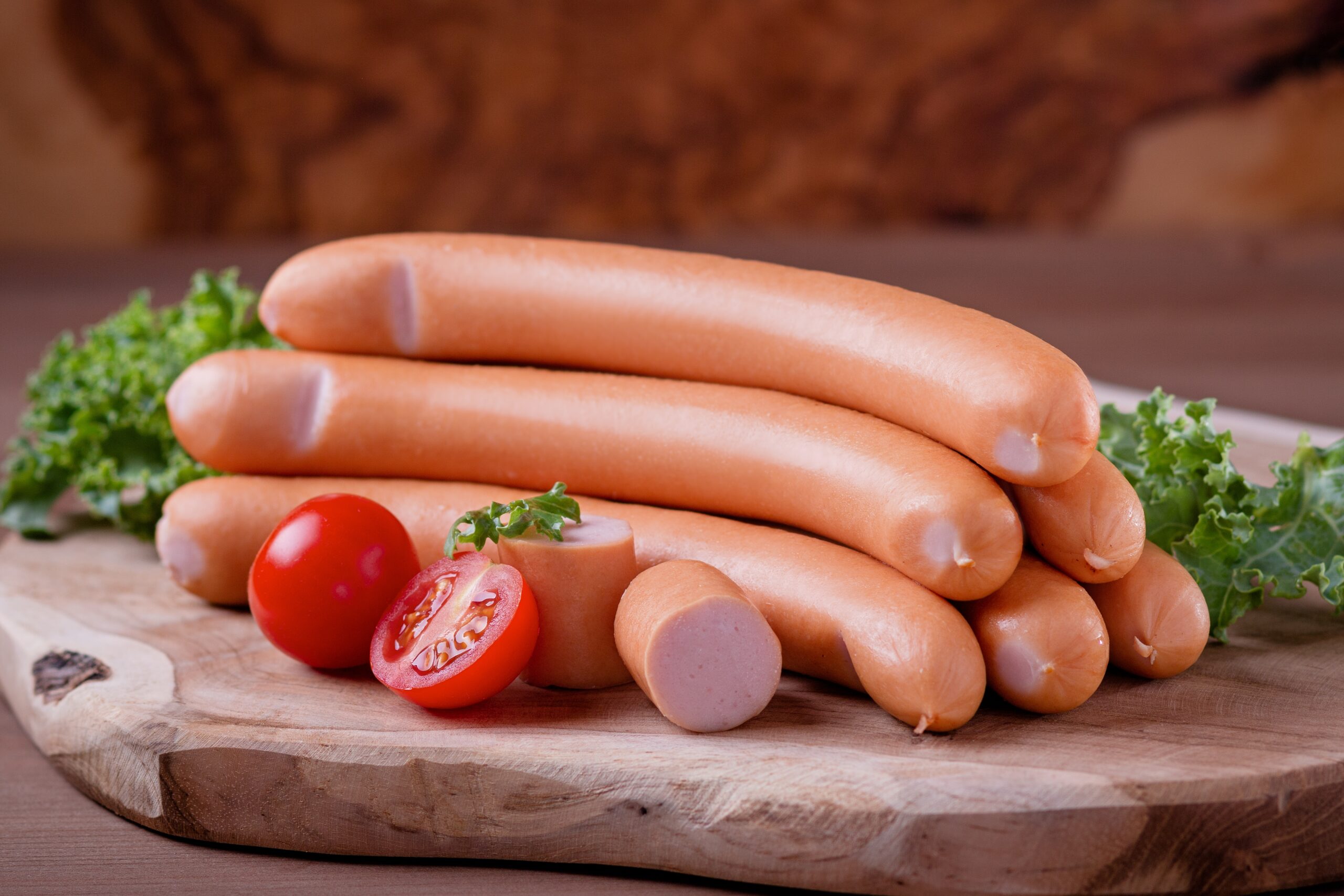 Styled,Frankfurter,Sausages,On,Wooden,Board,With,Tomatoes,And,Green